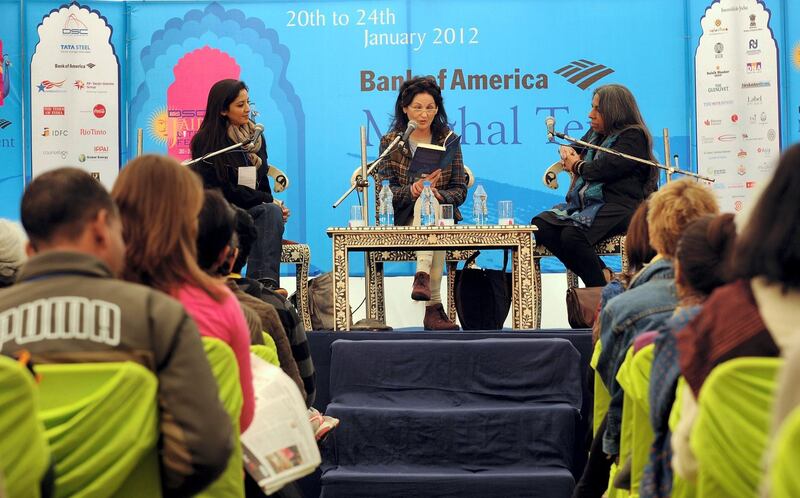 Lebanese author Hanan Al-Shaykh (C) reads from her book as Houda Echouafni (L) and Urvashi Butalia (R) listen along with visitors during DSC Jaipur Literature Festival (JLF) in Jaipur on January 23, 2012. British author Salman Rushdie is to address an Indian literature festival by video link after he was forced to pull-out in person because of protests by Islamic hardliners, organisers said on Monday. Rushdie's appearance at the DSC Jaipur Literature Festival was cancelled on Friday, with the Indian-origin writer citing alleged threats to his life from underworld gunmen who had been hired to kill him.. AFP PHOTO / Prakash SINGH / AFP PHOTO / PRAKASH SINGH