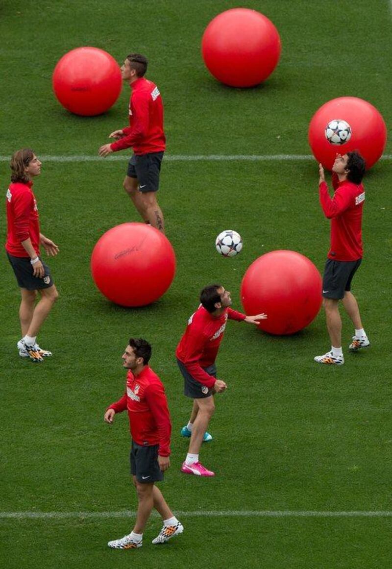 Atletico Madrid players Diego Godin, second right, Tiago Mendes, right, Koke, third left and Filipe Luis, left, train on Monday for Saturday's Champions League final. Gonzalo Arroyo Moreno / Getty Images / May 19, 2014