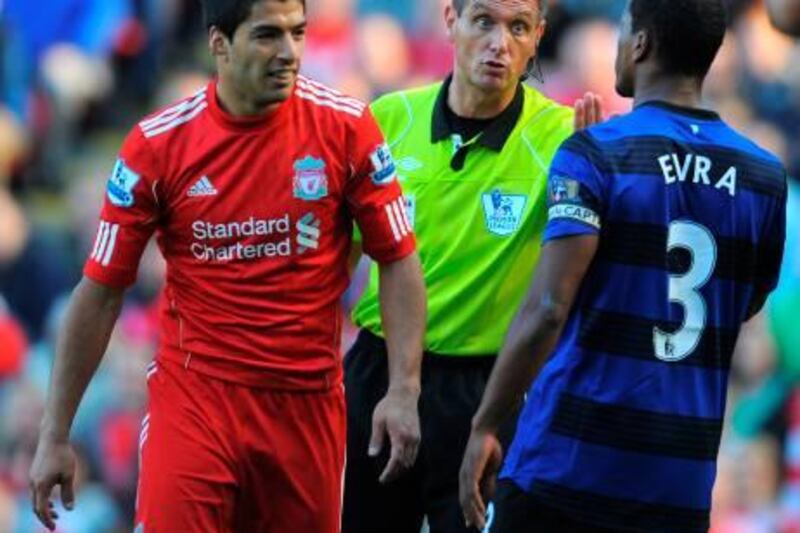 Referee Andre Marriner (C) talks to Liverpool's Uruguayan forward Luis Suárez (L) and Manchester United's French defender Patrice Evra during the English Premier League football match between Liverpool and Manchester United at Anfield in Liverpool, north-west England, on October 15 2011. Liverpool have denied on October 16 Suarez abused Evra during the match, the BBC reported. French and British media quoted Evra after the game as telling French broadcaster Canal+ that Suarez had racially abused him several times during the match.   AFP PHOTO / ANDREW YATES
RESTRICTED TO EDITORIAL USE. No use with unauthorized audio, video, data, fixture lists, club/league logos or “live” services. Online in-match use limited to 45 images, no video emulation. No use in betting, games or single club/league/player publications.