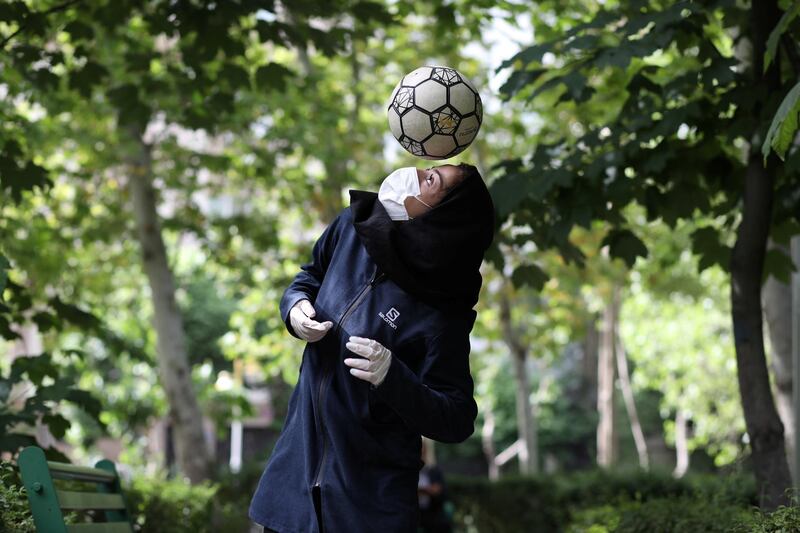 Iranian freestyle footballer Hosna Mirhadi, 23, wears a protective face mask and gloves as she trains with a ball  at a park in Tehran, Iran. WANA (West Asia News Agency)
