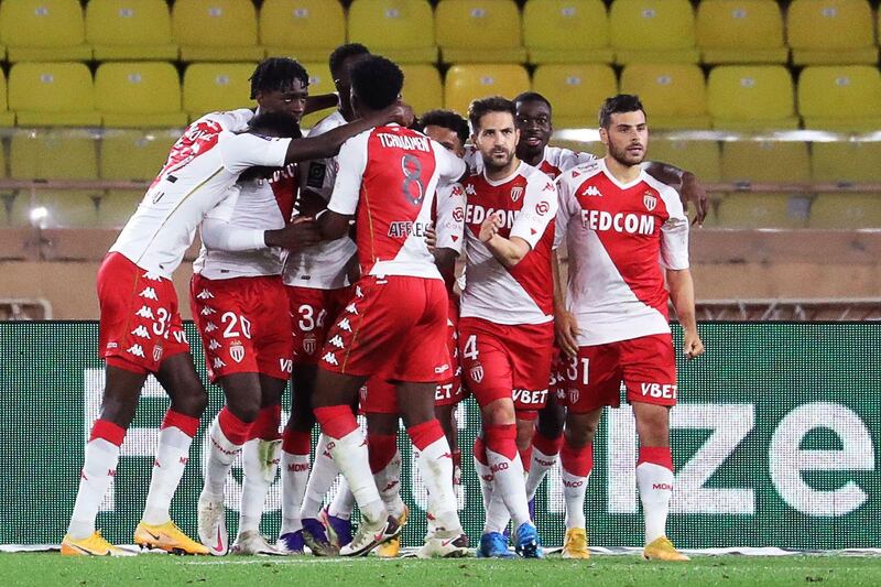 Monaco's Spanish midfielder Cesc Fabregas (C) celebrates with teammates after scoring from the penalty. AFP