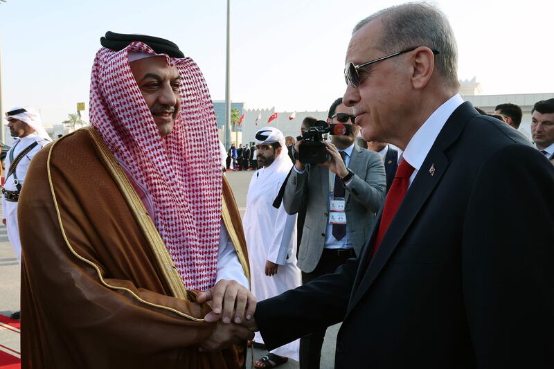 Qatar's Minister of State for Defence, Khalid bin Mohammad Al Attiyah, welcomes Mr Erdogan at the airport in Doha. AFP
