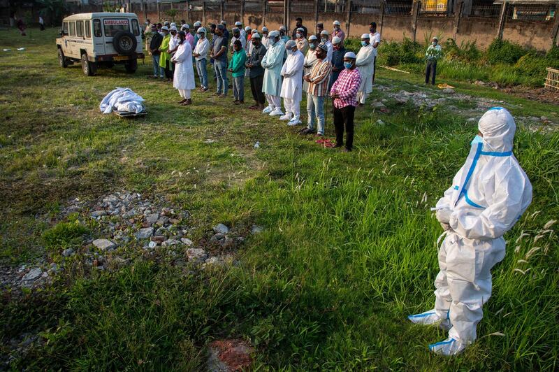Relatives offer prayers before they bury the body of a Covid-19 victim in Guwahati, the capital of north-east Indian state Assam. AP Photo