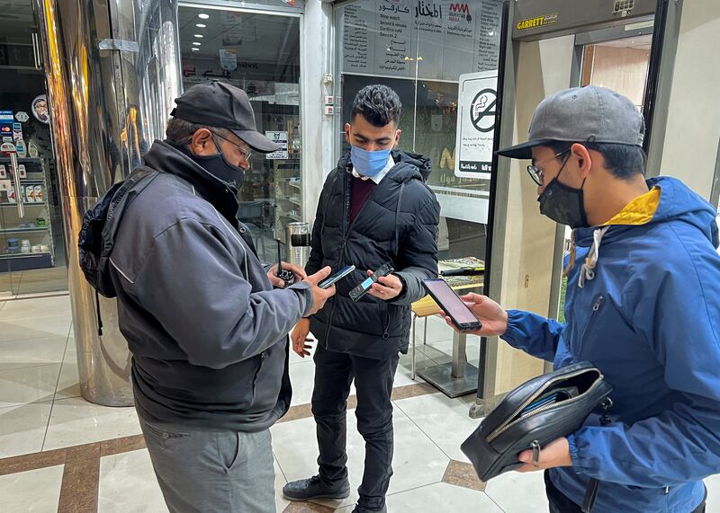 A security employee inspects people's vaccination status at the entrance of a shopping centre, amid a Covid-19 outbreak, in Amman, Jordan. Reuters