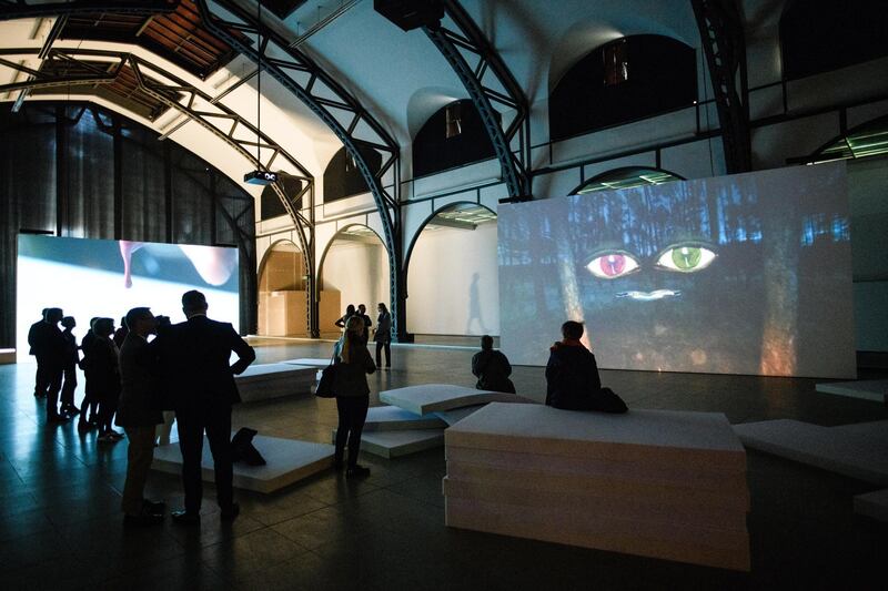 Visitors stand in front of a video installation of the artwork 'The Demon's Brain' by Polish artist Agnieszka Polska (not in the picture) at the 'Hamburger Bahnhof' exhibition hall in Berlin.  EPA