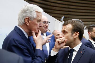 FILE - In this Saturday, Feb. 23, 2019 file photo, French President Emmanuel Macron, right, whispers to European Union chief Brexit negotiator Michel Barnier as he visits the International Agriculture Fair, in Paris, France. He's known throughout most of Europe as Mr. Brexit, but not so well known at home in France. With a new book out this week, and interviews in national media, Michel Barnier is trying to raise his profile ahead of next April's presidential election. (AP Photo/Michel Euler, Pool, File)