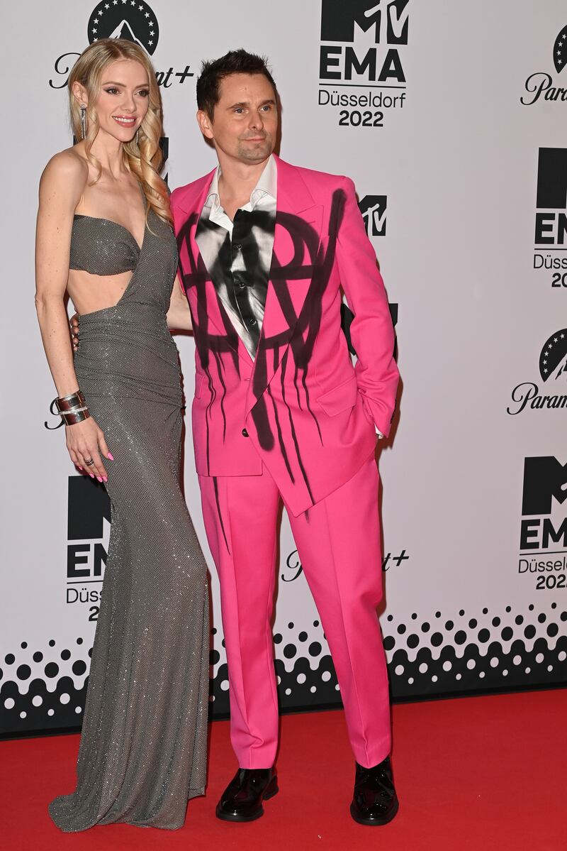 Elle Evans, wearing a one-shouldered grey dress, and Matthew Bellamy of Muse, wearing a pink spray painted suit. Getty Images 