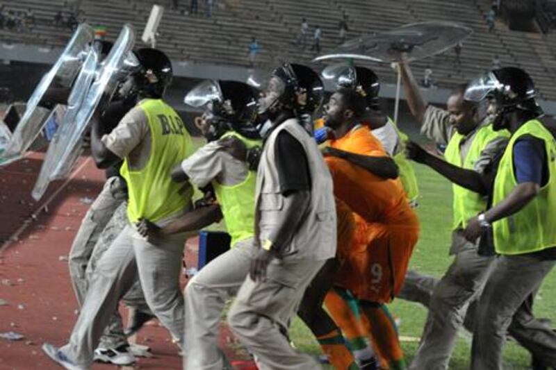 Newcastle's Cheick Tiote is among the Ivory Coast players escorted from the field under police protection after a riot by Senegal fans
