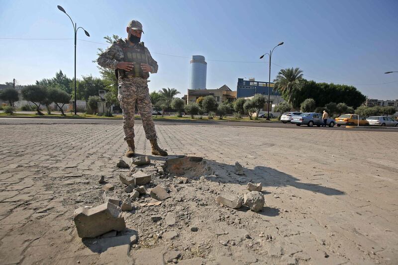 A member of the Iraqi security forces inspects the damage outside the Zawraa park in the capital Baghdad on November 18, 2020, after volley of rockets slammed into the Iraqi capital breaking a month-long truce on attacks against the US embassy.  According to the Iraqi military, four of the rockets landed in the high-security Green Zone, where the US embassy and other foreign missions are based.  Another three rockets also hit other parts of Baghdad, killing one girl and wounding five civilians. All seven rockets were launched from the same location in east Baghdad, the Iraqi military said in a statement. / AFP / AHMAD AL-RUBAYE
