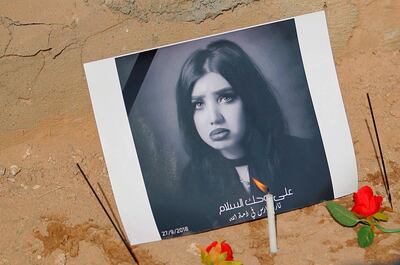 In this Monday, Oct. 1, 2018 photo, fans of slain former beauty queen, fashion model and social media star Tara Fares left flowers and  candles at her gravesite, in Najaf, Iraq. Fares won fame in conservative, Muslim-majority Iraq with outspoken opinions on personal freedom. Last week, she was shot and killed at the wheel of her white Porsche on a busy Baghdad street. The violence reverberated across Iraq and follows the slaying of a female activist in the southern city of Basra and the mysterious deaths of two well-known beauty experts. (AP Photo/Anmar Khalil)