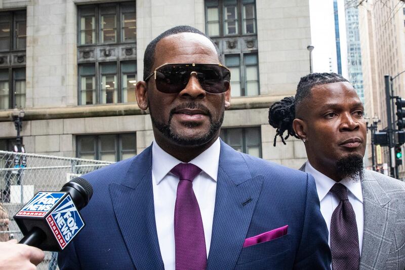 FILE - This March 13, 2019 file photo shows R. Kelly and his publicist Darryll Johnson, right, leaving The Daley Center after an appearance in court for Kelly's child support case in Chicago. Prosecutors in Chicago have charged Kelly with 11 new sex assault charges, some that are more serious than those first filed against him in February. The Chicago Sun-Times reported Thursday, May 30, on its website that the charges include counts that carry a potential sentence of up to 30 years in prison. The charges say the alleged offenses happened in 2010. (Ashlee Rezin/Chicago Sun-Times via AP, File)