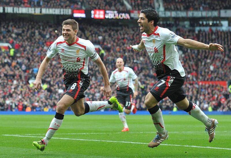 Liverpool midfielder Steven Gerrard, left, celebrates with Luis Suárez after Gerrard scored his team's second goal during the Premier League match against Manchester United at Old Trafford on March 16, 2014. Paul Ellis / AFP