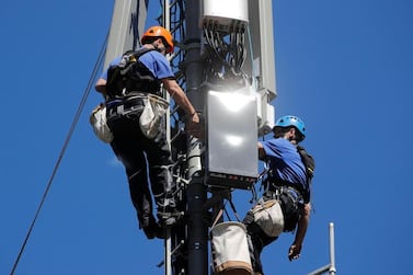 Technicians are roped up as they install 5G antennas. The new network is expected to carry 35 per cent of mobile data traffic globally by 2024, according to Ericsson. Reuters