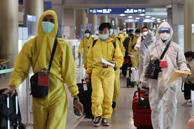 Passengers wearing protective gear at Incheon International Airport in South Korea, where health authorities have imposed an entry ban on foreign arrivals from eight African countries, including South Africa. EPA