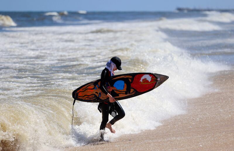 Ms Abu Ghanem comes in from the sea after time spent surfing.