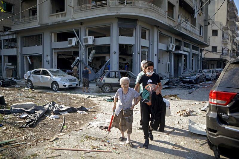 A woman is evacuated from the partially destroyed Beirut neighbourhood of Mar Mikhael.  AFP