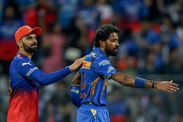 Mumbai Indians' captain Hardik Pandya and Royal Challengers Bengaluru's Virat Kohli (L) gesture at the end of the Indian Premier League (IPL) Twenty20 cricket match between Mumbai Indians and Royal Challengers Bengaluru at the Wankhede Stadium in Mumbai on April 11, 2024.  (Photo by INDRANIL MUKHERJEE  /  AFP)  /  -- IMAGE RESTRICTED TO EDITORIAL USE - STRICTLY NO COMMERCIAL USE --