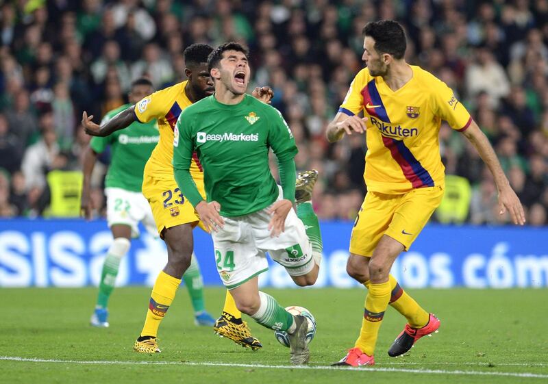 Barcelona's Sergio Busquets, right, and Samuel Umtiti battle with Real Betis' Juanjo Narvaez. AFP