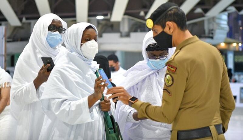 A police officer checks a pilgrim's Tawakalna app at the Grand Mosque in Makkah