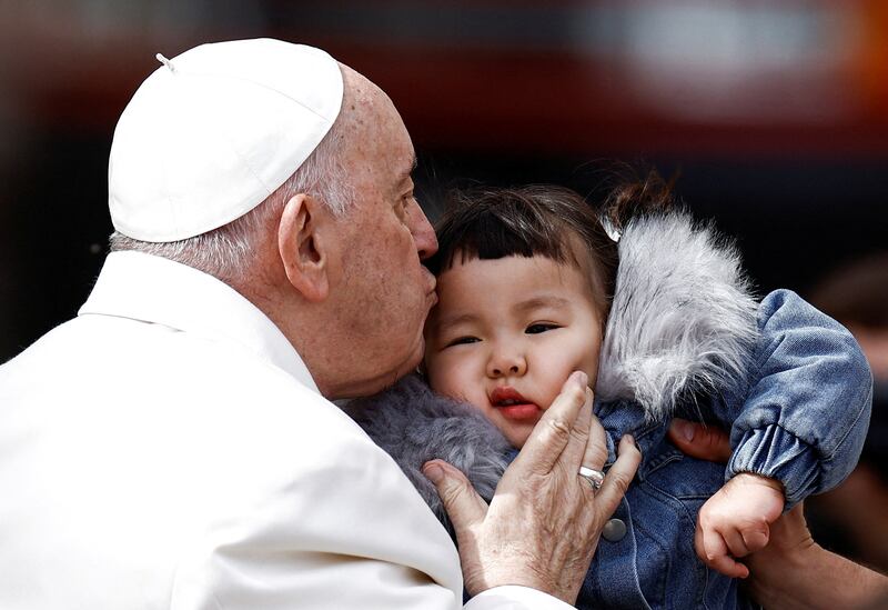 Pope Francis kisses a child at his weekly general audience in St Peter's Square at the Vatican. Reuters