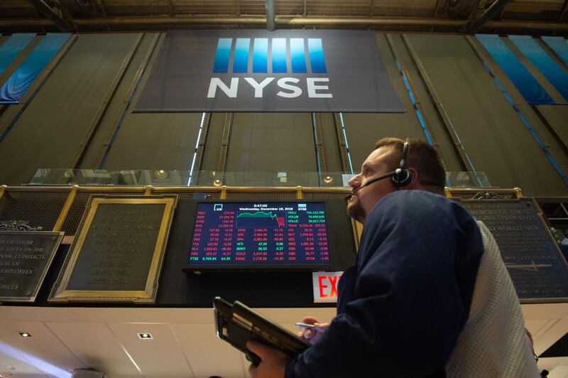 Traders work on the floor at the closing bell of the Dow Industrial Average at the New York Stock Exchange on December 19, 2018 in New York. Wll Street stocks tumbled Wednesday, December 19, 2018 after the Federal Reserve lifted interest rates while pledging a cautious approach to additional interest rate hikes next year. At the closing bell, the Dow Jones Industrial Average was down 1.5 percent, about 350 points, at 23,324.10. The broad-based S&P dropped 1.5 percent to 2,506.87, while the tech-rich Nasdaq Composite Index sank 2.2 percent to 6,635.48. Major indices had been up about one percent prior to the Fed announcement.  / AFP / Bryan R. Smith
