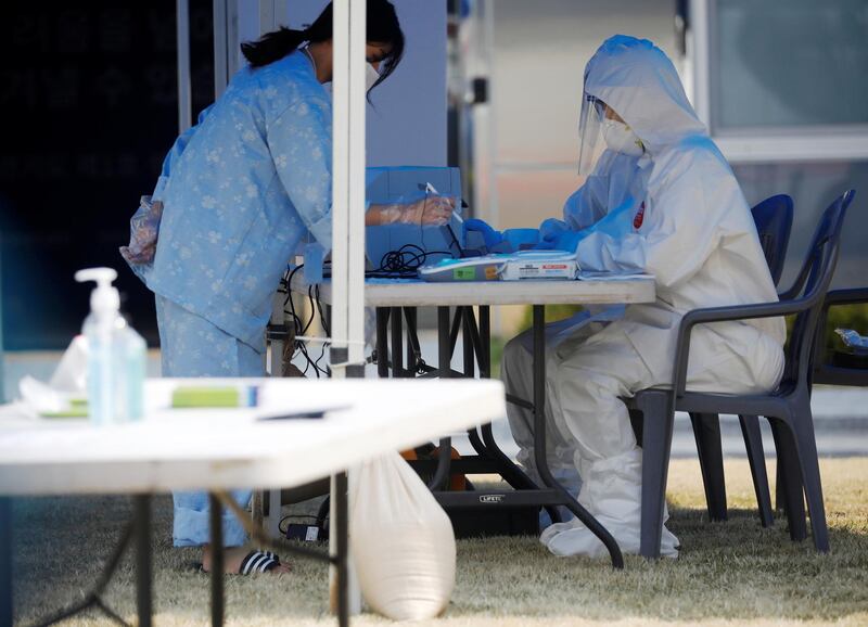 A South Korean patient of Covid-19 arrives to cast her ballot for the parliamentary election at a polling station set up at a quarantine centre in Yongin, April 11. Kim Hong-Ji/ Reuters