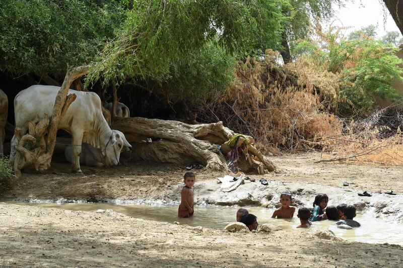 In this photograph taken on August 11, 2017, Pakistani children cool themselves off in a stream during a hot day in Sibi, in Pakistan's southwestern Balochistan province.
Scientists have warned that swathes of South Asia may be uninhabitable due to rising temperatures by 2100 -- and in the desert community of Sibi in southwest Balochistan province, where the mercury hit 52.4 degrees Celsius (126 Fahrenheit) this summer, it feels like they could be right.  / AFP PHOTO / BANARAS KHAN / TO GO WITH PAKISTAN-ENVIRONMENT-CLIMATE-HEAT, FOCUS BY MAAZ KHAN