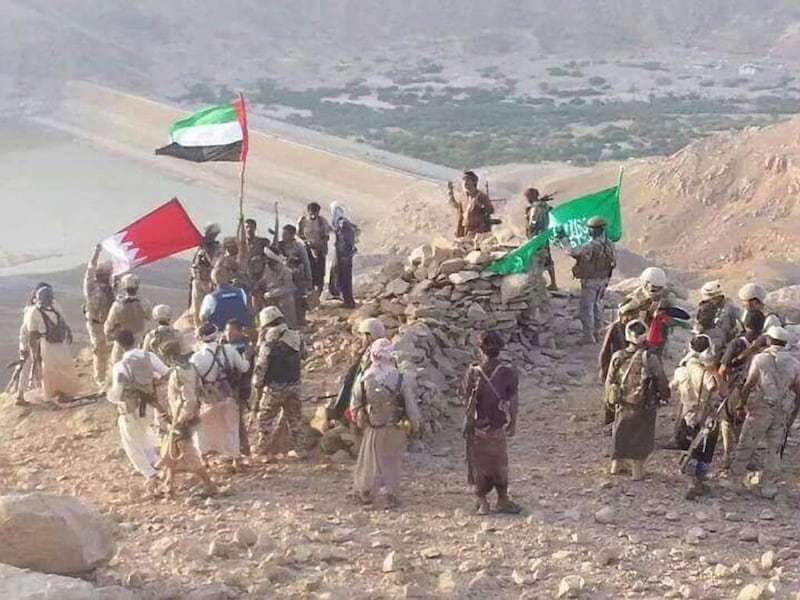 Pro-government forces and Arab coalition troops raise the flags of the UAE, Saudi Arabia and Bahrain on a hill above the Marib Dam on September 29. The dam was captured from Houthi rebels on September 28 . Photo courtesy of the Yemeni military 