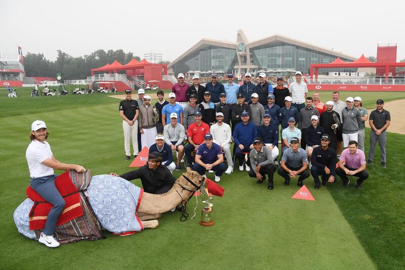 Players and officials pose for photos ahead of the Abu Dhabi HSBC Championship as defending champion Tommy Fleetwood sits on a camel. Ross Kinnaird / Getty Images