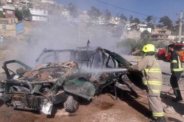 Fire fighters try to extinguish a police vehicle which was hit by magnetic bomb in Kabul, Afghanistan July 28, 2020. REUTERS