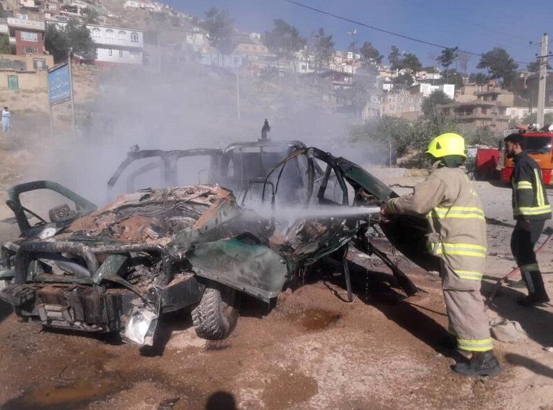 Fire fighters try to extinguish a police vehicle which was hit by magnetic bomb in Kabul, Afghanistan July 28, 2020. REUTERS/Stringer