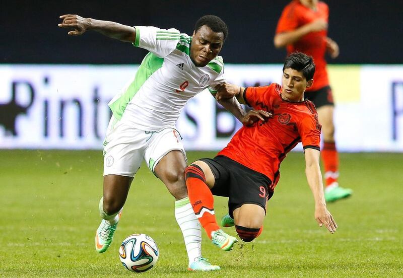 Emmanuel Emenike, left, of Nigeria protects the ball against Alan Pulido of Mexico during a friendly at the Georgia Dome in Atlanta on March 5, 2014. Kevin C Cox / AFP

