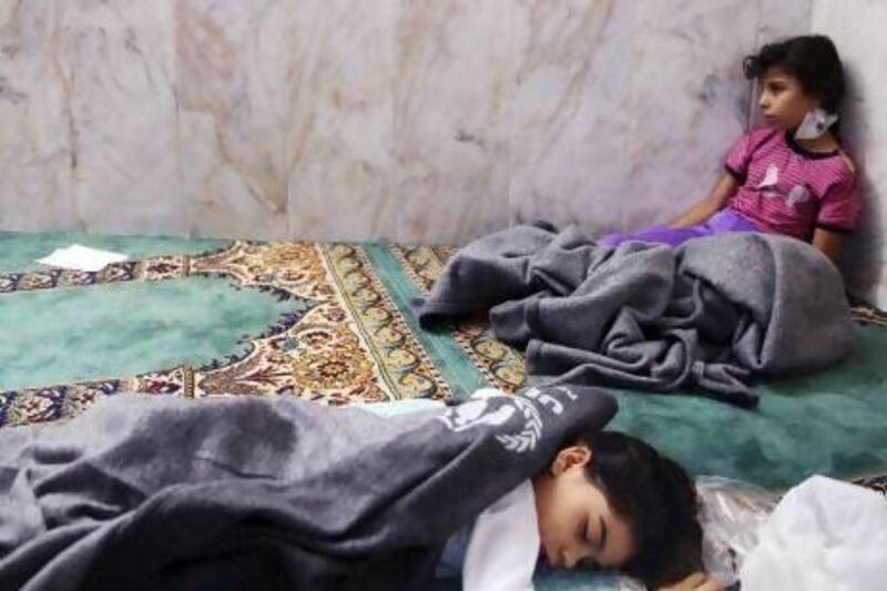 Girls who survived what activists describe as a gas attack rest inside a mosque in the Duma neighbourhood of Damascus.