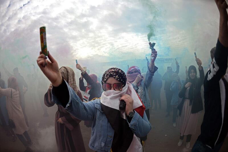 Iraqi demonstrators wave colourful smoke cartridges during the first colour festival outside the Kufa University in the holy city of Najaf.   AFP
