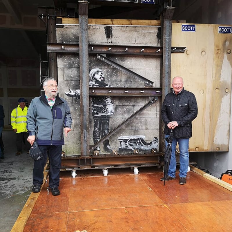 Art dealer John Brandler, left, with garage owner Ian Lewis, with Banksy's 'Season's Greetings' before its removal to an art gallery.