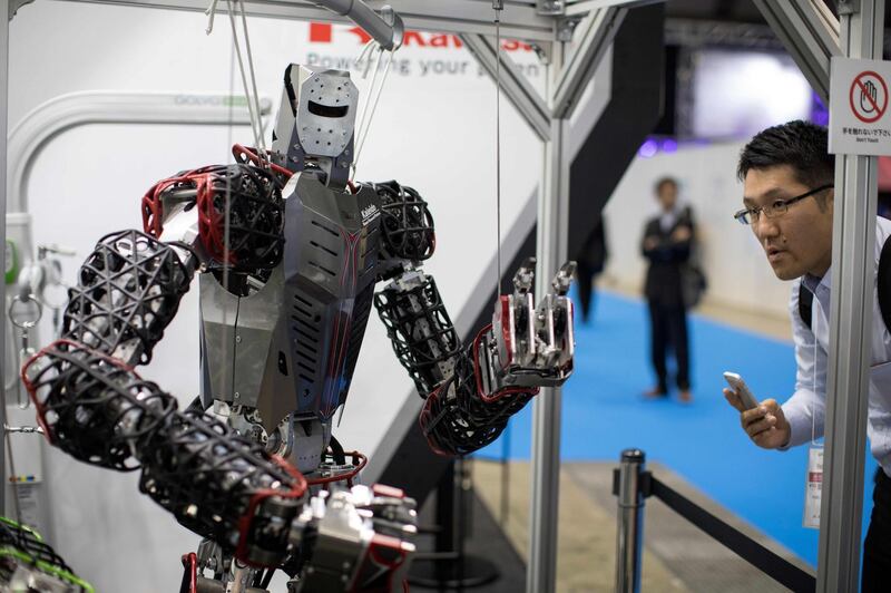 A visitor takes pictures of Kawasaki's life-size humanoid robot at the World Robot Summit in Tokyo on October 18, 2018. Forget the flashy humanoids with their gymnastics skills: at the World Robot Summit in Tokyo, the focus was on down-to-earth robots that can deliver post, do the shopping and build a house. / AFP / Behrouz MEHRI
