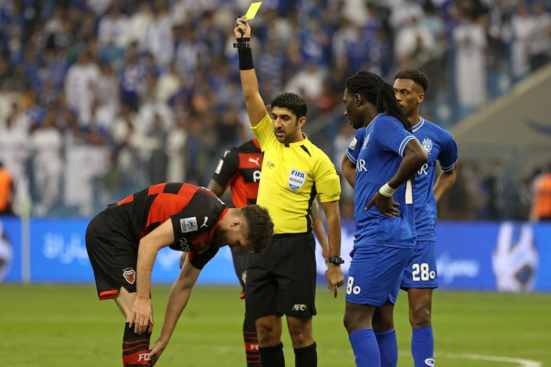 Emirati referee Mohammed Abdulla Hassan shows a yellow card to Pohang defender Alex Grant. AFP