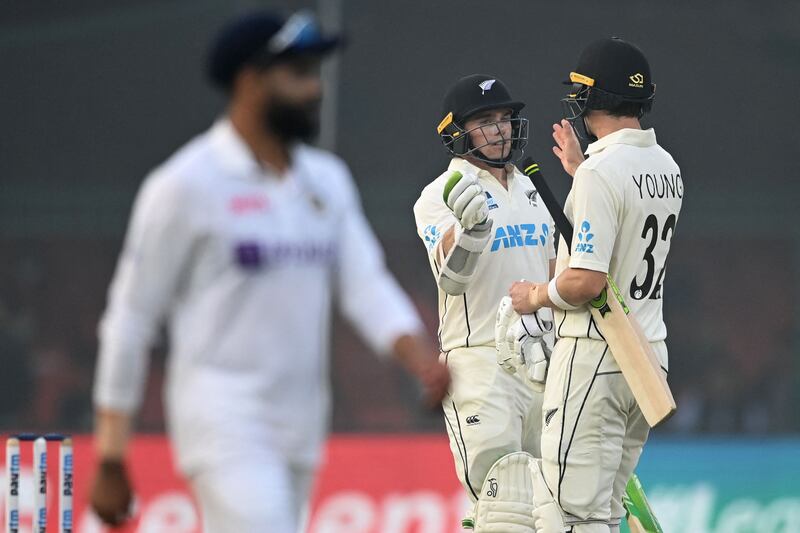 New Zealand's Tom Latham (C) is congratulated by teammate Will Young (R) after he scored a half-century (50 runs) on the second day of the first Test cricket match between India and New Zealand at the Green Park Stadium in Kanpur on November 26, 2021.  (Photo by Sajjad HUSSAIN  /  AFP)  /  IMAGE RESTRICTED TO EDITORIAL USE - STRICTLY NO COMMERCIAL USE