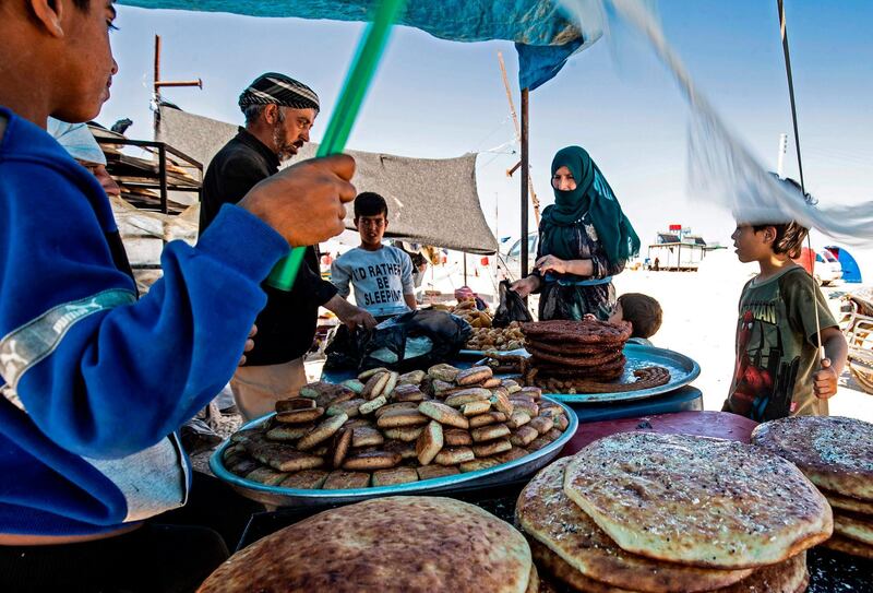 Displaced Syrians wait for their order of sweets at the Washukanni camp for the internally displaced in Syria's northeastern Hasakeh province, during Ramadan.  AFP