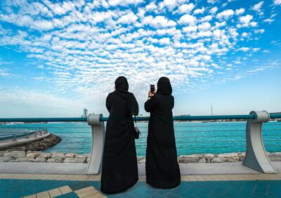 Abu Dhabi, United Arab Emirates, March 3, 2021.  Friends enjoy the view of tiny cotton ball like clouds at the Corniche before sunset. 
Victor Besa / The National
Section:  NA
For:  Big Picture/Stock Images/Standalone