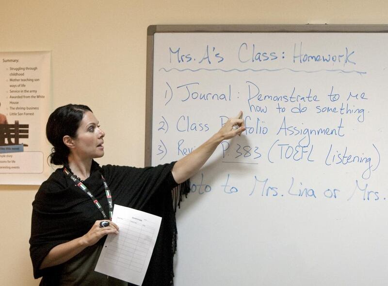 An instructor points to homework assignments for high school students taking the Summer Outreach Programme to help them to prepare for college at the American University of Sharjah. Jeff Topping/The National

 