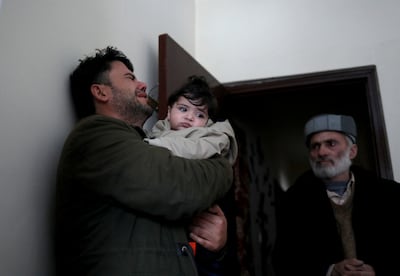 Hamid Safi, a taxi driver who found baby Sohail Ahmadi in Kabul airport, cries as he hands the boy over to his grandfather. Reuters