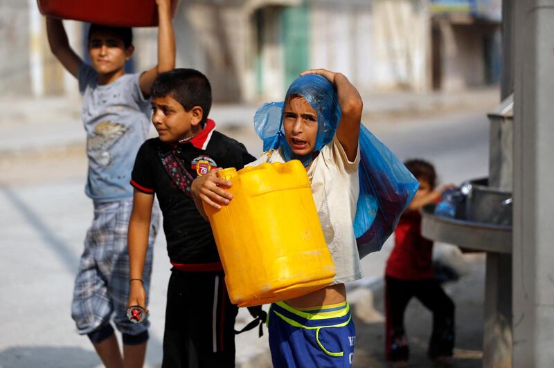 A Palestinian boy holds a plastic container near a public tap on August 26, 2014 in Gaza City. Most residents in the Palestinian enclave suffered from water shortages even before the recent fighting between Hamas militants and Israel but now Monzer Shoblak, an official from the local water board, said war damage meant that Gaza was pumping 50 percent less water.  AFP PHOTO / MOHAMMED ABED (Photo by MOHAMMED ABED / AFP)