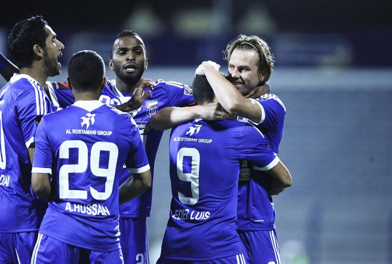 Al Nasr players congratulate Brett Holman, far right, after he scored the first goal against Ajman/ Lee Hoagland/The National