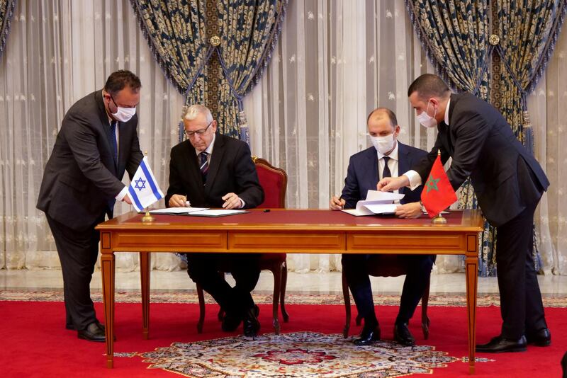 Unidentified Moroccan and Israeli officials sign memorandums of understanding during a visit by Israeli envoys to Rabat, Morocco.  REUTERS