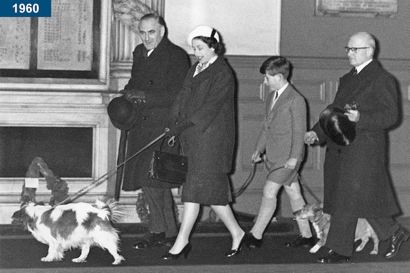 1960: The queen and Prince Charles walk through Liverpool Street Station in London with their dogs, having returned by train from Sandringham after the Christmas holidays.