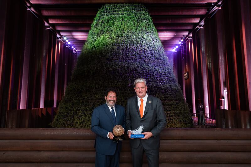 Carel Richter, consul general and commissioner general of the Netherlands pavilion (left), and Niels Bouwman, pavilion director hold innovation awards at the Expo pavilion in front of a cone covered with thousands of edible plants and herbs. Photo: Netherlands Pavilion Expo 2020 Dubai