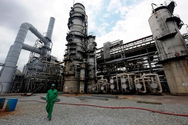 A worker walks past a refinery in Nigeria's southern oil hub, Port Harcourt. Many oil-producing nations in sub-Saharan Africa are now having to cut budgets that were set based on an average oil price of $50-$60 per barrel. AFP