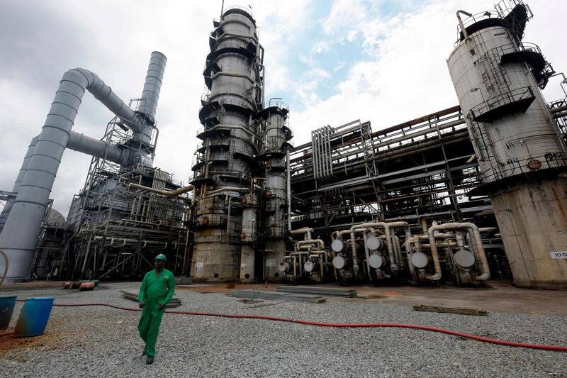 (FILES) In this file photo taken on September 16, 2015, a worker walks past the Port Harcourt refinery built in 1989, Rivers State.  A poverty gap and widening inequality between the largely-Muslim north and Christian-majority south, has caused a north-south migration in Nigeria. Climate change has hit agricultural yields hard and insecurity has rendered many areas unsafe to farm. The effect has been increased migration to cities such as Lagos, Nigeria's capital Abuja and the southern oil-hub Port Harcourt, where jobs are easier to come by. / AFP / Pius Utomi EKPEI
