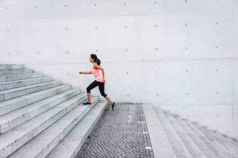 Woman running up steps in urban setting